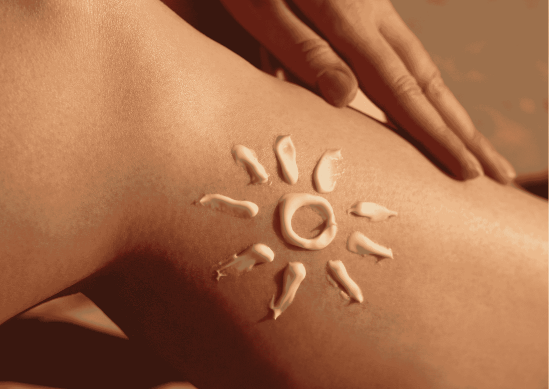 Sonnencreme in Form einer Sonne auf der Haut, Nahaufnahme; Hand streicht über den Oberschenkel, Fokus auf Hautpflege