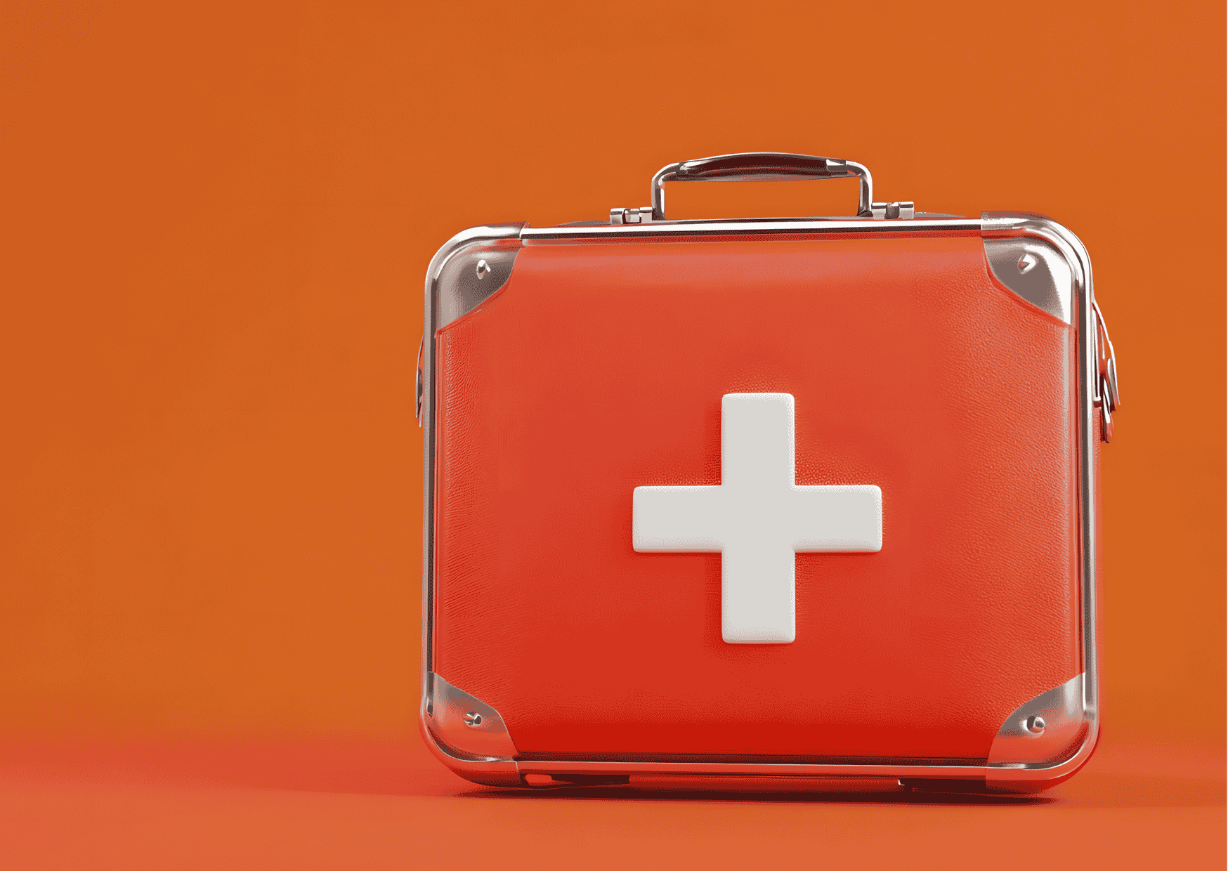 Roter Erste-Hilfe-Koffer mit weißem Kreuz auf orangefarbenem Hintergrund; Symbol für Reiseapotheke