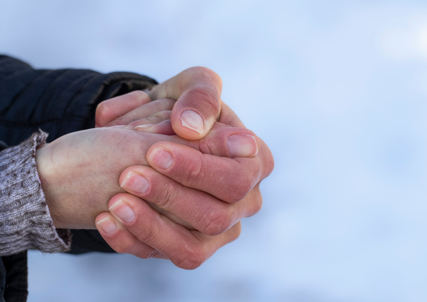 Hände einer Person eng ineinandergelegt, sichtbare Kälte oder Anspannung; Symbolbild für Frieren, Durchblutungsstörungen oder Kältegefühl