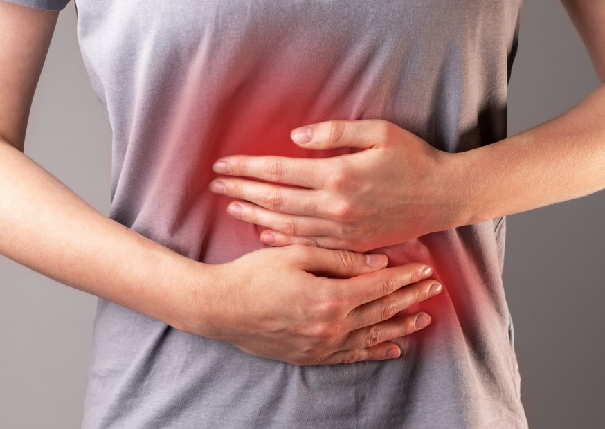 Frau hält sich den Bauch mit beiden Händen. Der Bauch ist rot geärbt
