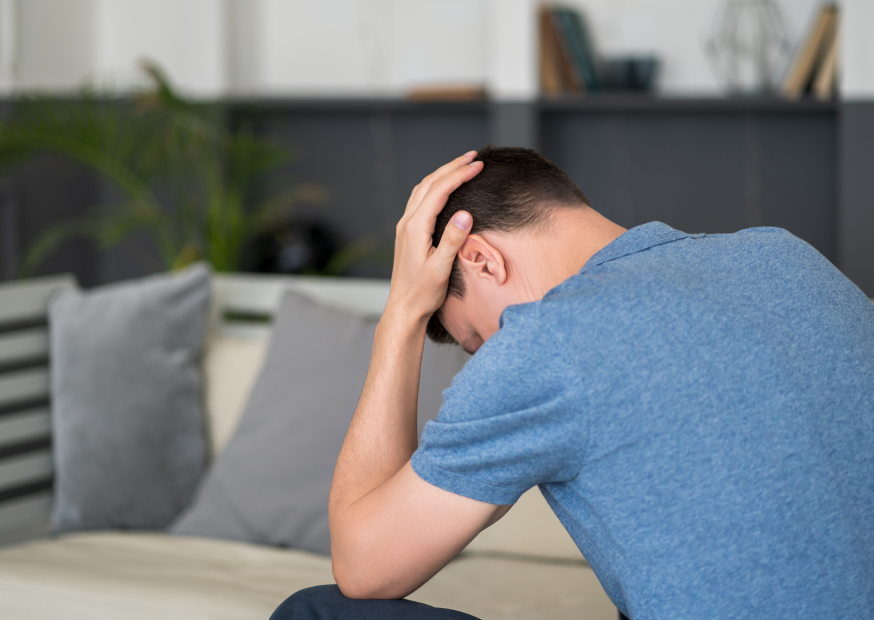 Mann mit einem blauen Shirt schlägt die Hände über dem Kopf 