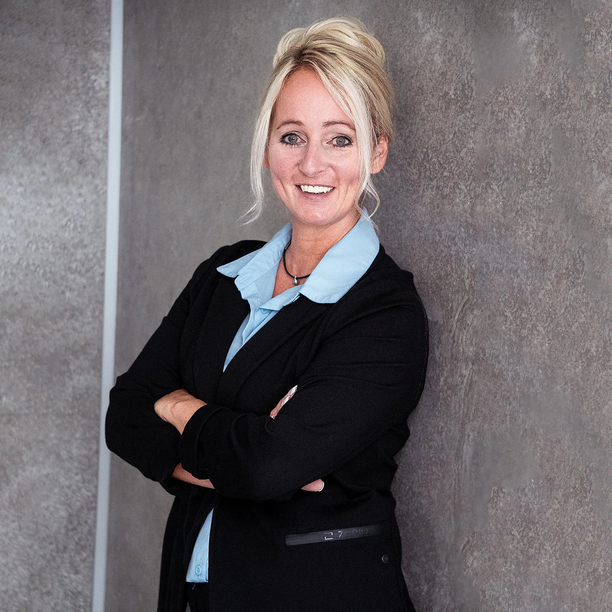 Portraitaufnahme Sandra Lungen vor grauer Wand