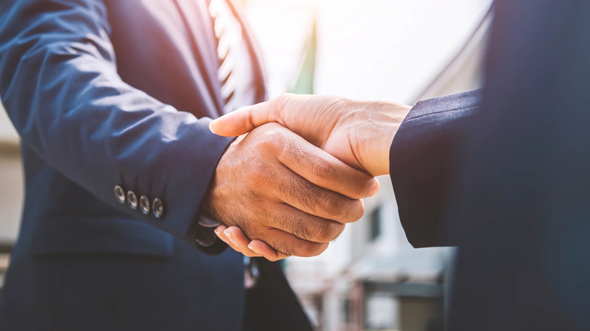 Zwei Geschäftsleute, ein Mann und eine Frau, geben sich die Hand nach erfolgreicher Geschäftsverhandlung.