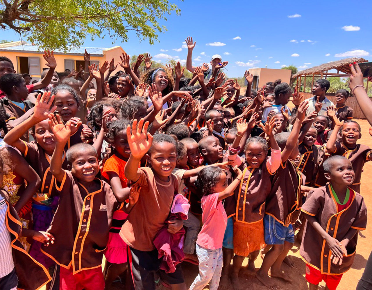 Lächelnde Kinder in Madagaskar winken in die Kamera